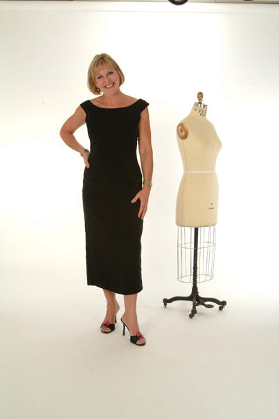 Model poses in a Stevie Black Dress beside a dress mannequin